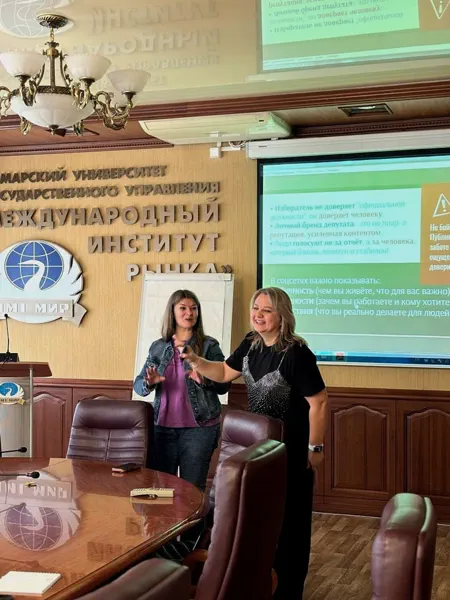 Наталья с коллегой перед экраном на конференции в Университете «МИР»